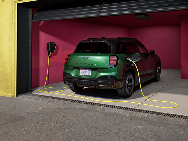 Den fuldelektriske MINI Aceman i British Racing Green set bagfra, mens den oplader i en garage. 