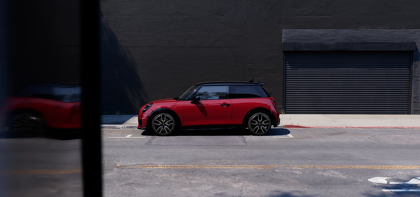 Parkeret MINI Cooper set fra siden i Chili Red med sort tag.
