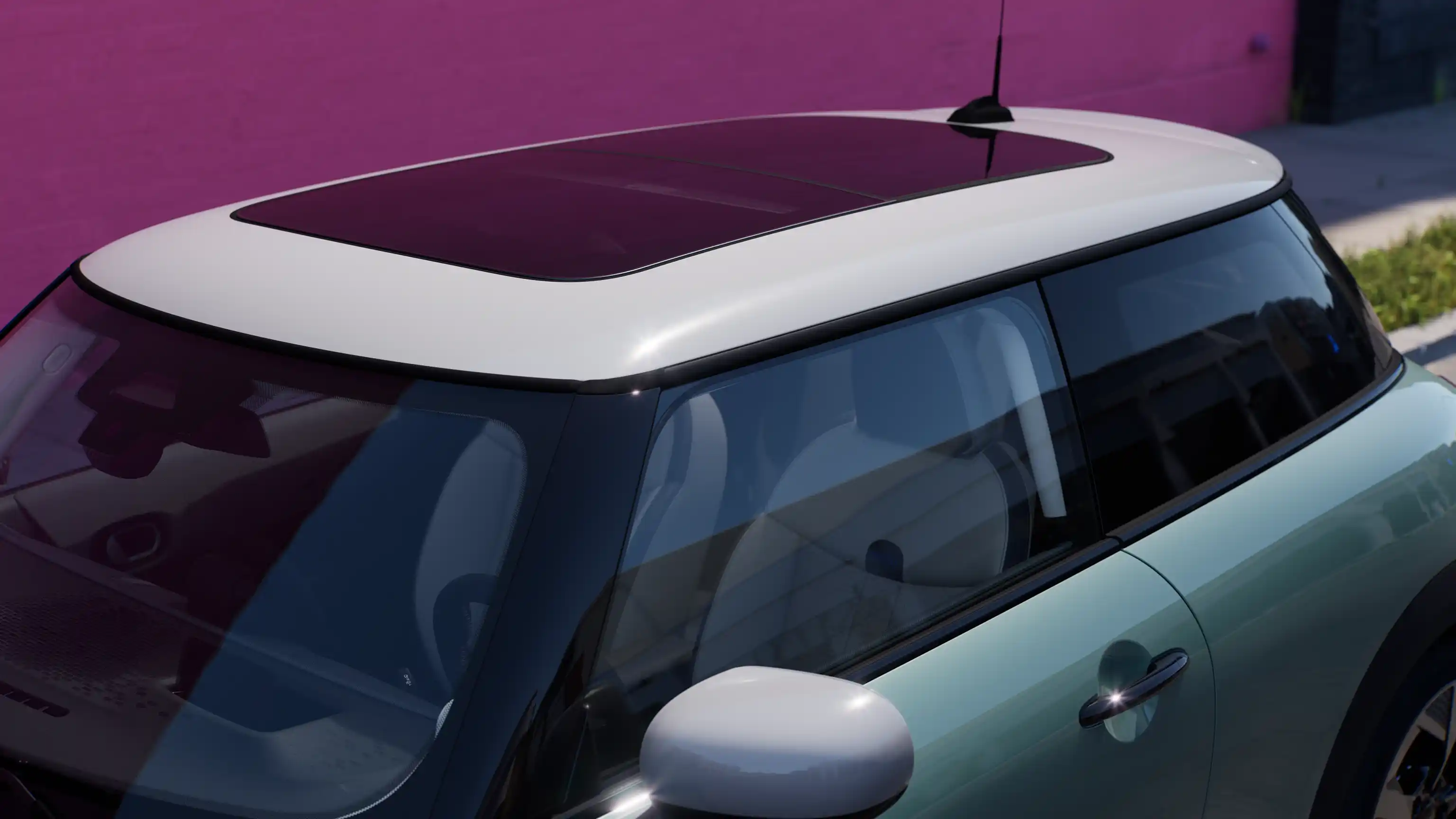 Visning af MINI Cooper i Ocean Wave Green set oppefra med tag i kontrastfarve og stort glastag.