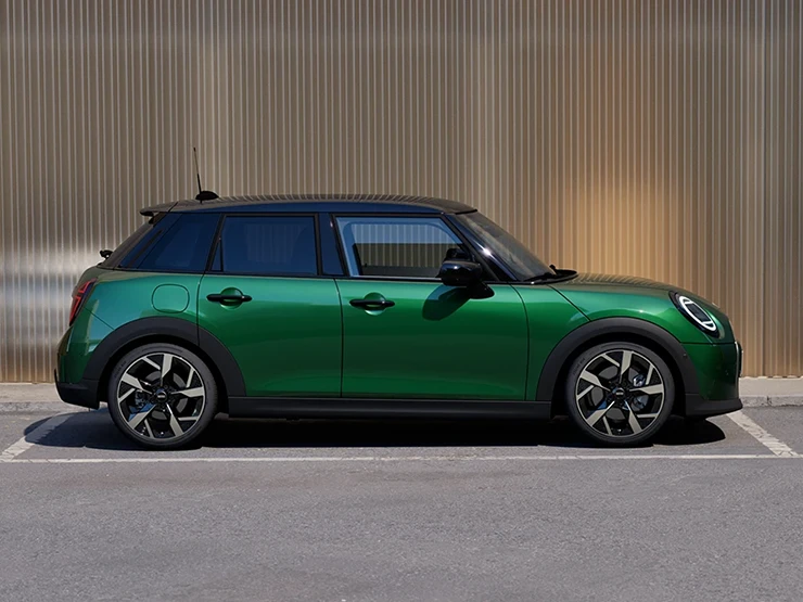 Billede fra siden af parkeret MINI Cooper 5-dørs i British Racing Green med sort tag.