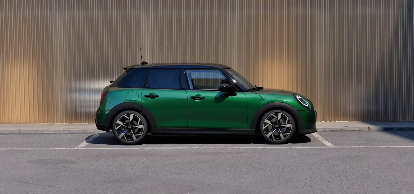 Billede fra siden af parkeret MINI Cooper 5-dørs i British Racing Green med sort tag.