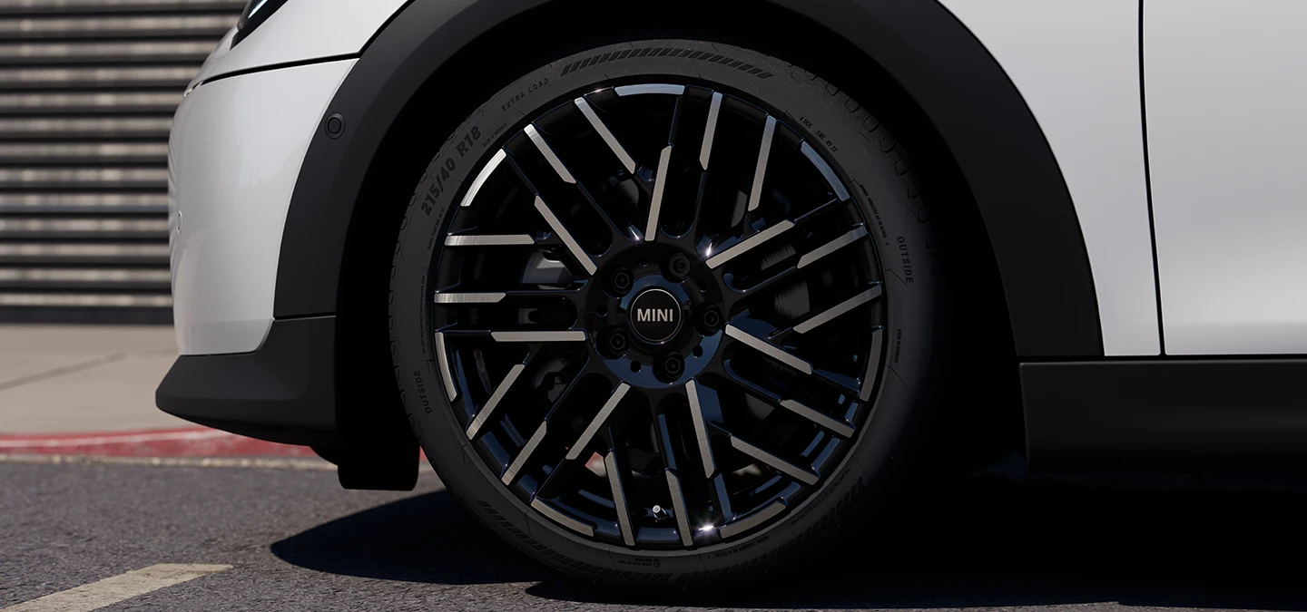 Nærbillede af MINI Cooper 5-dørs i Nanuq White med fælge i Night Flash Spoke 2-tone.