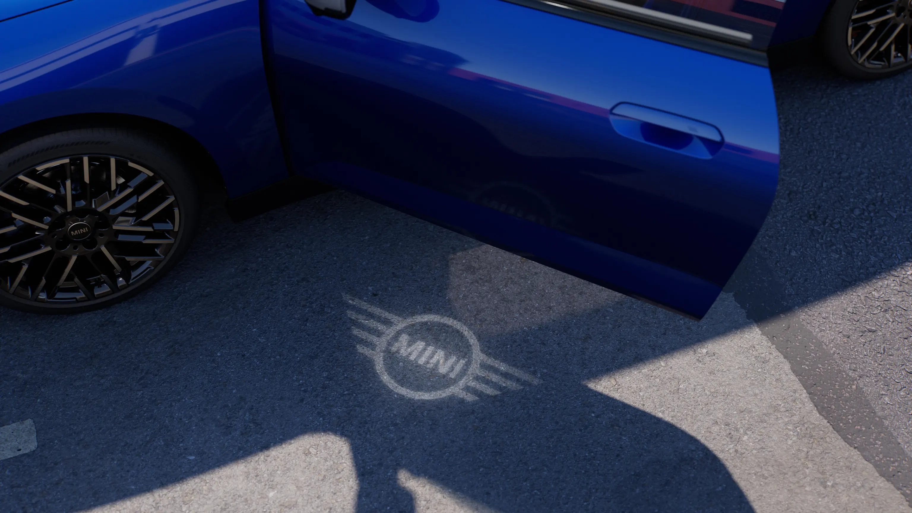 Eksteriørbillede af den fuldelektriske MINI Cooper med åben dør og MINI logoets velkomstlys på jorden