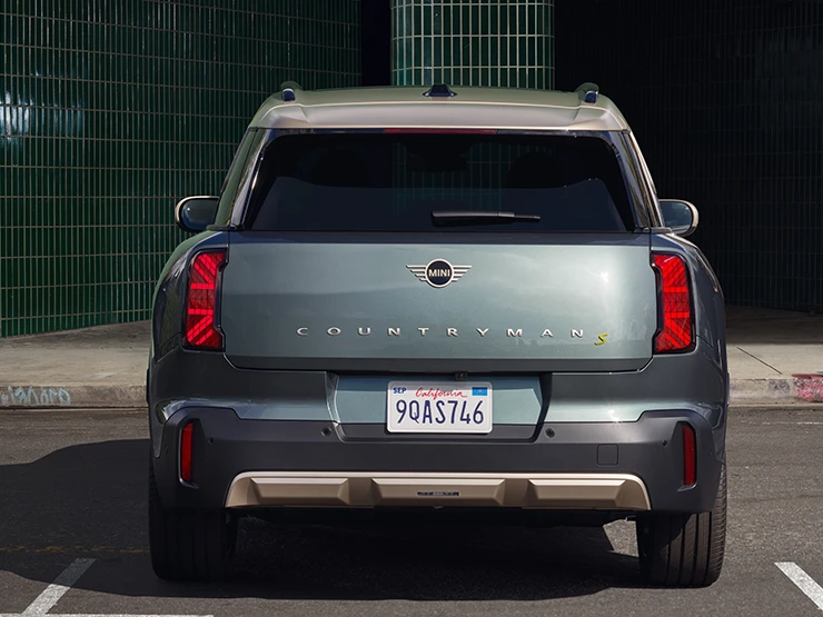 Den fuldelektriske MINI Countryman i Smokey Green med tag i Vibrant Silver set bagfra. 
