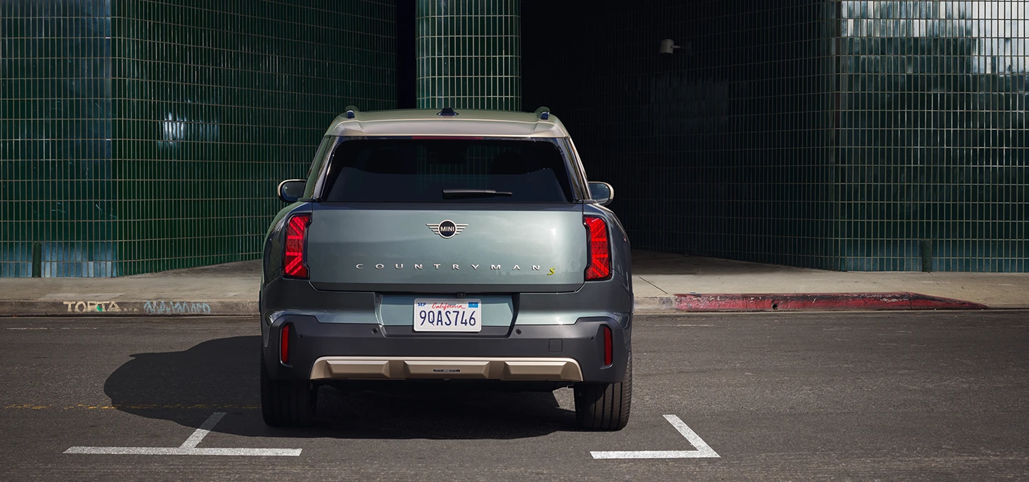 Den fuldelektriske MINI Countryman i Smokey Green med tag i Vibrant Silver set bagfra. 