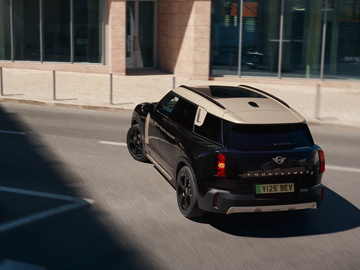 Den fuldelektriske MINI Countryman i Midnight Black med tag i Vibrant Silver set bagfra fra oven.