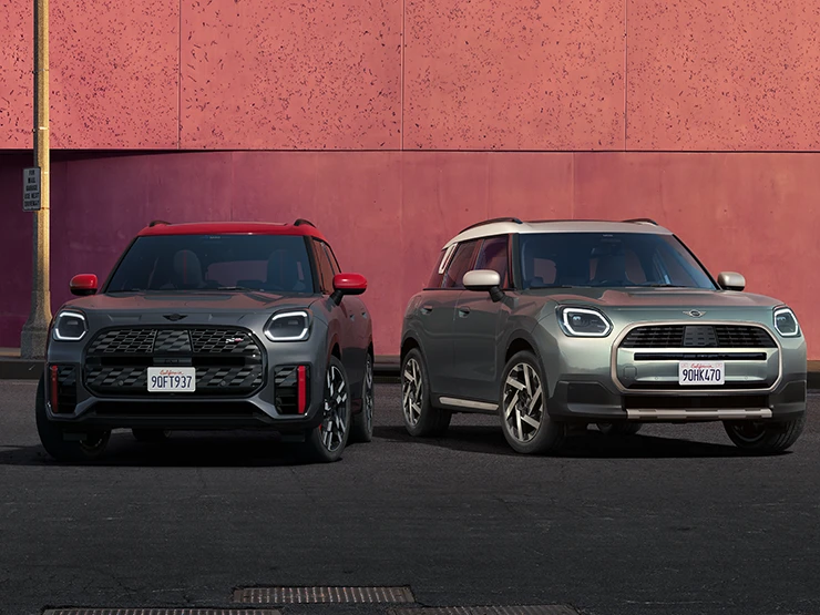 MINI Countryman JCW i Legend Grey med rødt tag set forfra og MINI Countryman i Smokey Green og tag i Vibrant Silver ved siden af hinanden.