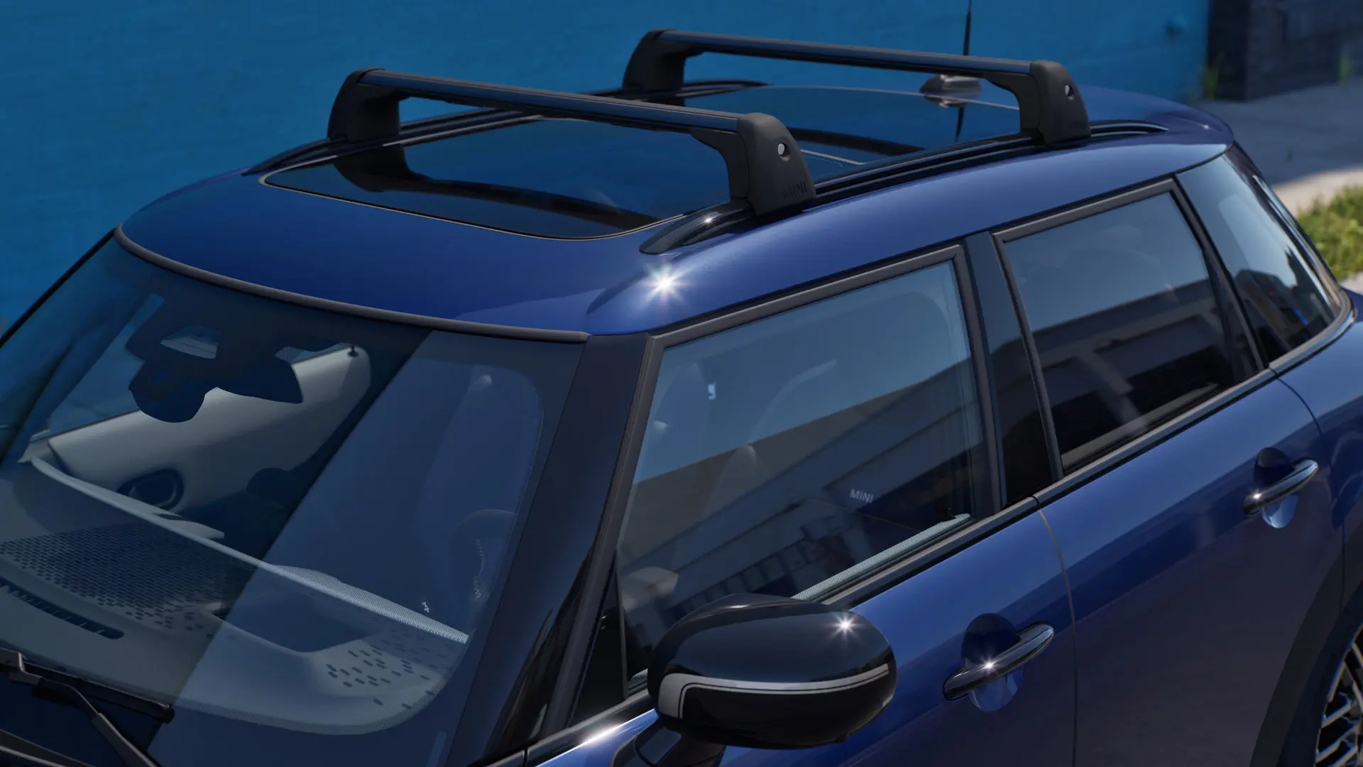 Nærbillede forfra og fra siden af en MINI Aceman i Indigo Sunset Blue med MINI Tagbøjler. 