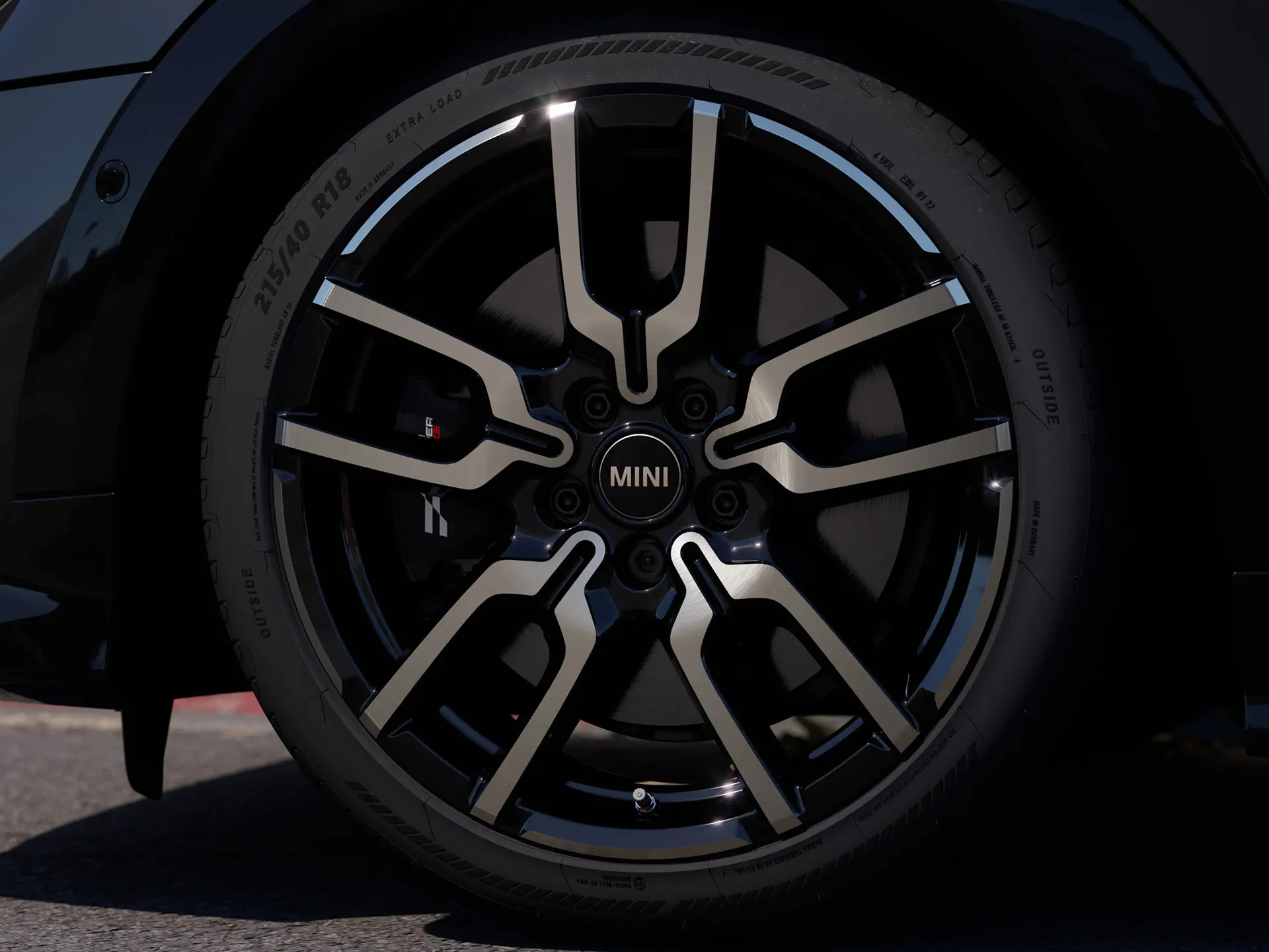 Nærbillede af JCW alufælg I Jet Black med Lap-eger, der viser fælgens karakteristiske design med åbne eger. 