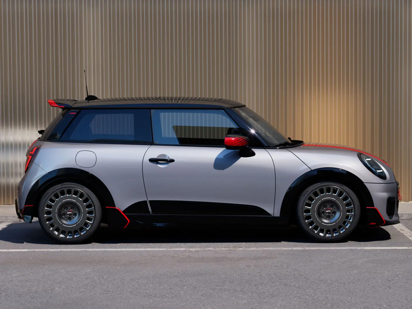 MINI Cooper 3-dørs i Melting Silver med John Cooper Works-tagspoiler for forbedrede aerodynamiske egenskaber – set fra siden.