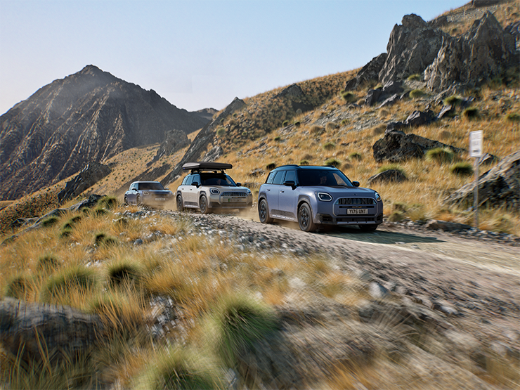 Billede af flere MINI Countryman Untamed Edition-modeller, der deler oplevelsen af offroad-kørsel på en bjergvej.